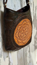 Load image into Gallery viewer, Angled view of the Boho Rustic Soul Mandala Leather Crossbody Bag featuring genuine leather, hand-tooled mandala artwork and an adjustable crossbody strap. Designed in Australia by Dreamtime Boho.
