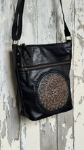 Load image into Gallery viewer, Angled view of the Boho Harmony black genuine leather crossbody bag with hand-tooled mandala artwork, turquoise accents and front zip pocket. Designed in Australia by Dreamtime Boho.