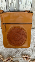 Load image into Gallery viewer, Front view of handcrafted tan genuine leather crossbody bag featuring an intricate hand-tooled mandala panel and front zip pocket. Designed in Australia by Dreamtime Boho.