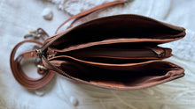Load image into Gallery viewer, Interior of brown 3-way leather crossbody clutch showing three large zip compartments and card slots.