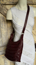 Load image into Gallery viewer, Small burgundy woven leather boho crossbody bag worn on mannequin featuring artisan weave detailing and adjustable leather strap.