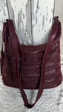 Load image into Gallery viewer, Front view of burgundy woven leather boho shoulder bag with tassel detail and adjustable strap.