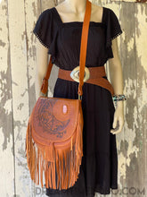 Load image into Gallery viewer, Bohemian tan leather fringe crossbody bag with hand tooled crystal moon design worn by model featuring pink gemstone detail