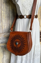 Load image into Gallery viewer, Desert Wings mandala hand tooled leather crossbody bag worn crossbody with boho dress showing artisan leather craftsmanship.