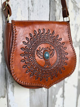 Load image into Gallery viewer, Angled view of Desert Wings mandala hand tooled leather bohemian crossbody bag with turquoise stone centrepiece.