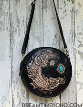 Load image into Gallery viewer, Rustic Moon hand tooled round leather bag shown at an angle highlighting detailed moon carving, Dreamtime Boho