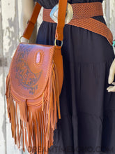 Load image into Gallery viewer, Handcrafted tan leather boho bag with hand tooled moon artwork and fringe shown on model side view