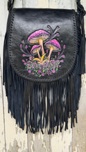 Load image into Gallery viewer, Black boho leather bag with colourful hand-painted mushroom and wildflower artwork, braided leather edging and long genuine leather fringe.