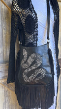 Load image into Gallery viewer, Model wearing black handpainted snake leather boho crossbody bag with flowing fringe and artisan western bohemian styling