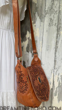 Load image into Gallery viewer, Tan Floral Spirit hand tooled leather crossbody boho bag showing carved floral design and brass stud accents.
