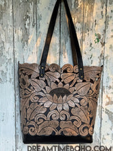Load image into Gallery viewer, Antique black hand tooled lotus leather tote shoulder bag shown at an angle, handcrafted boho style