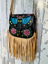 Load image into Gallery viewer, Side view of Midnight Starfall hand painted leather fringe crossbody bag showing pink rose detail, blue wings and long tan leather fringe