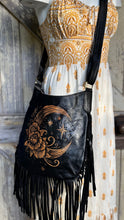 Load image into Gallery viewer, Close up of crescent moon and floral hand tooled design on black leather boho bag.