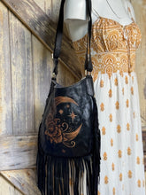 Load image into Gallery viewer, Hand tooled moon and floral leather fringe boho crossbody bag worn with a bohemian dress.