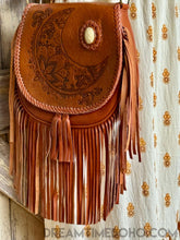 Load image into Gallery viewer, Close up of hand tooled crystal moon leather boho bag with pink gemstone feature and flowing fringe