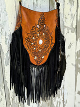 Load image into Gallery viewer, Side view of Sahara Moon mandala black and tan leather fringe boho bag showing hand-tooled detailing and flowing leather fringe