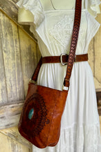 Load image into Gallery viewer, Soft genuine leather mandala crossbody bag worn with white boho dress, featuring hand tooled design, turquoise stone centre and adjustable detailed strap