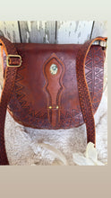 Load image into Gallery viewer, Close up of antique finish hand tooled leather crossbody bag with detailed strap and stud accents