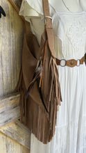 Load image into Gallery viewer, Wild Spirit taupe suede leather fringe shoulder bag styled with a white bohemian dress, featuring long suede fringe and decorative feathers.