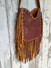 Load image into Gallery viewer, Angle view of hand carved floral leather boho fringe shoulder bag with artisan tooling